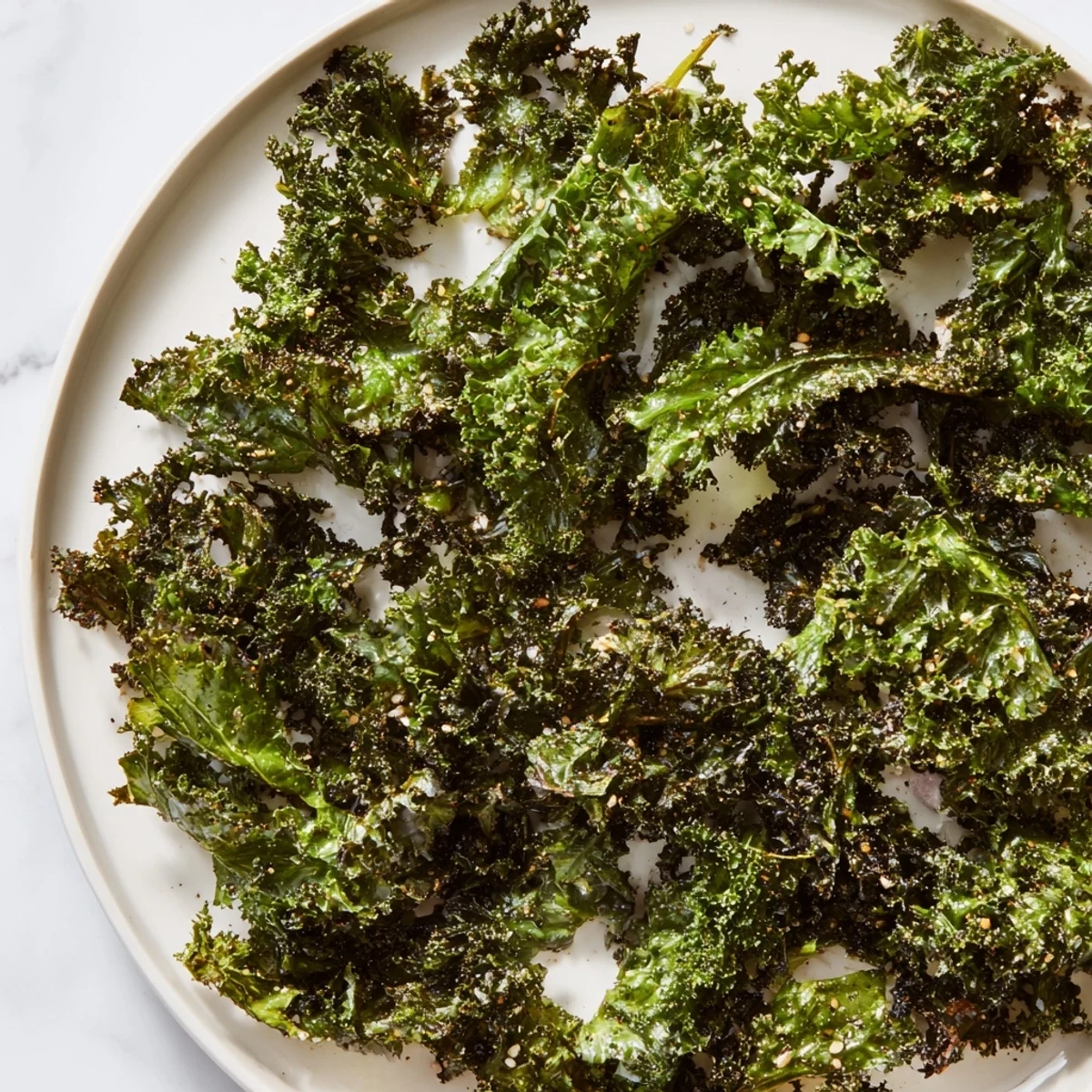 Golden-brown, crispy kale chips baked to perfection, seasoned with salt and paprika for a savory snack.
