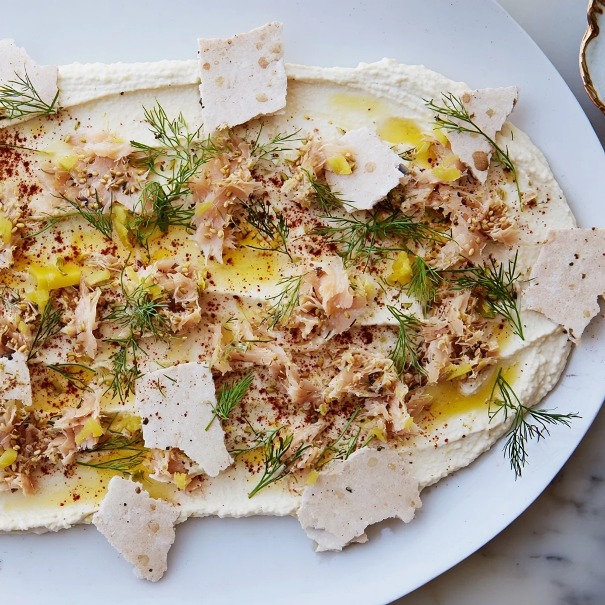 Artfully arranged The Driftwood Beach features crackers, smoked fish, and garnished hummus on a platter.