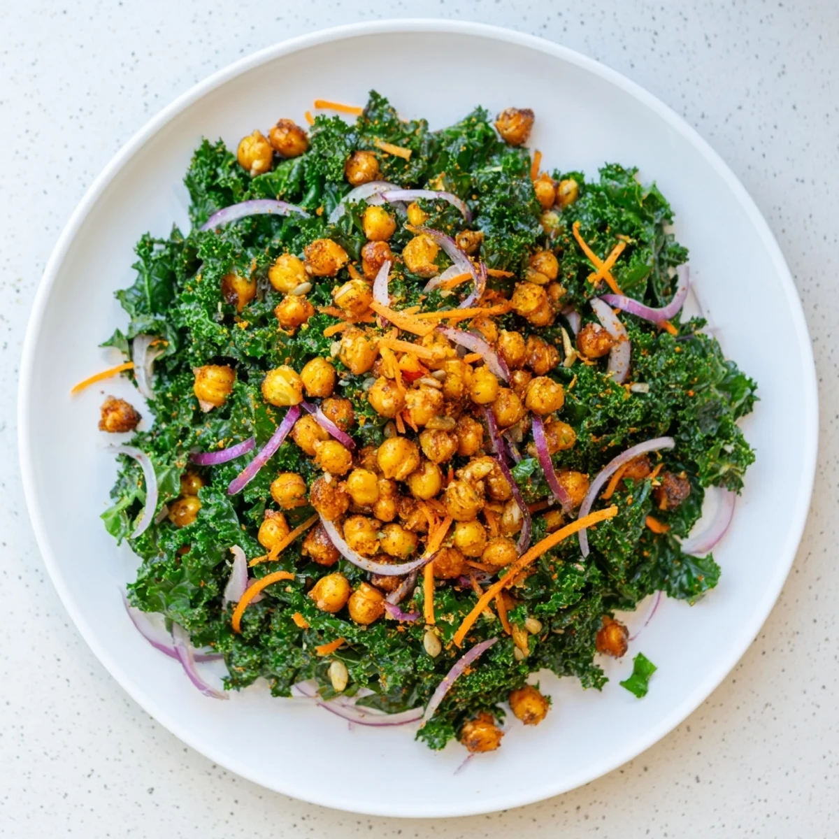 Close-up of a rustic bowl filled with fresh Kale Salad with Roasted Chickpeas, an easy vegan recipe.