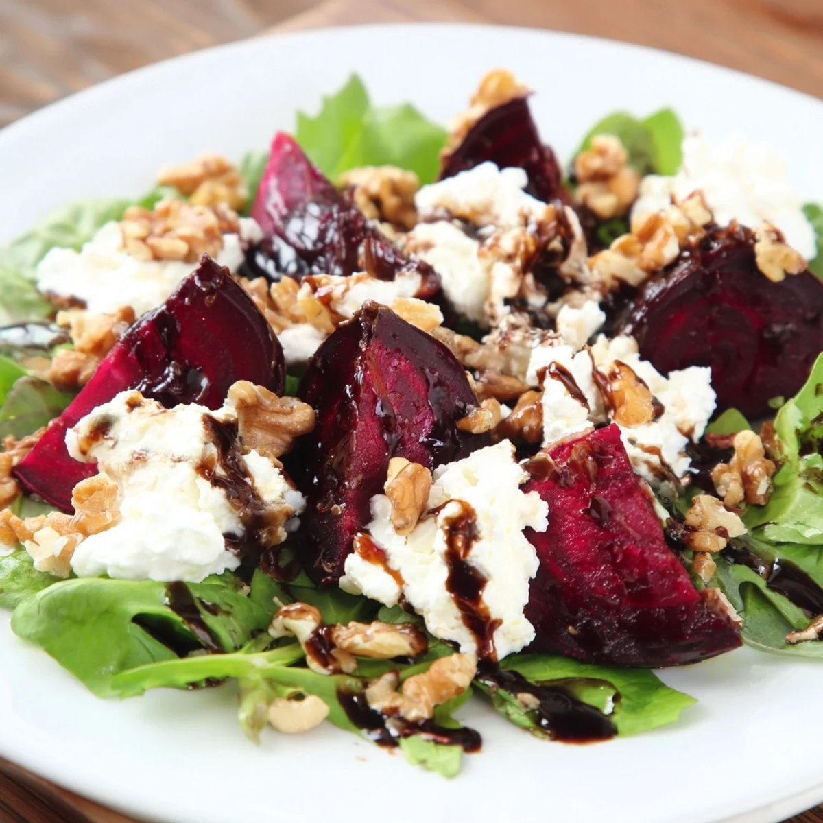 Freshly plated Beet and Goat Cheese Salad with roasted beet wedges, goat cheese crumbles, and walnuts.