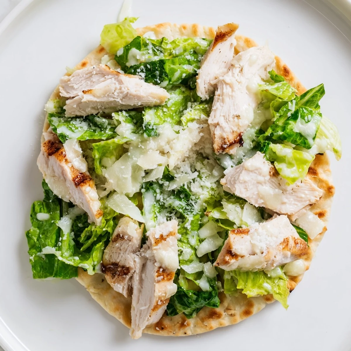 Golden, crispy flatbread base layered with tender grilled chicken, fresh romaine, and a drizzle of tangy Caesar dressing for a satisfying meal.  