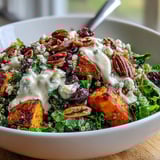 Fork-ready Harvest Kale Quinoa Bowl with crunchy pecans, sweet cranberries, and tangy blue cheese on a rustic wooden board.