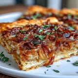 Savory French Onion Puff Pastry Tart, bubbling with cheese, perfect as an appetizer.