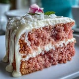 Delicate pink rosé velvet cake boasts a luscious cream cheese frosting and gold drizzle.
