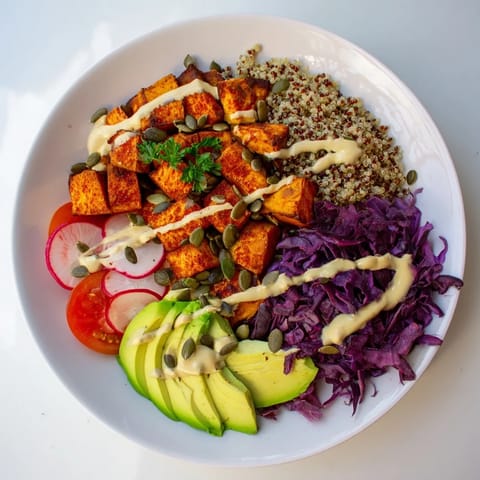 This Complete Veggie Bowl presents a colorful mix of ingredients, from roasted sweet potato to fresh greens and tahini.