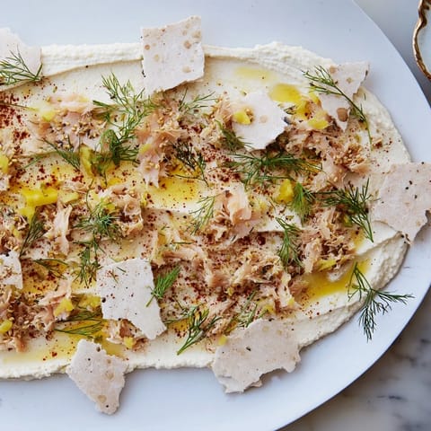 Artfully arranged The Driftwood Beach features crackers, smoked fish, and garnished hummus on a platter.