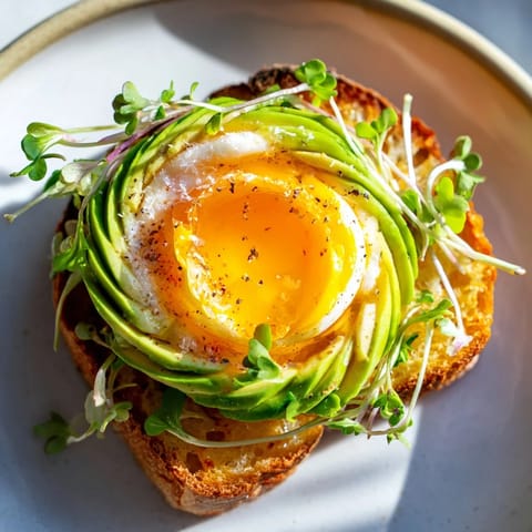 Fluffy cloud toast 2.0 with golden egg whites, avocado roses, and a honey drizzle for breakfast.