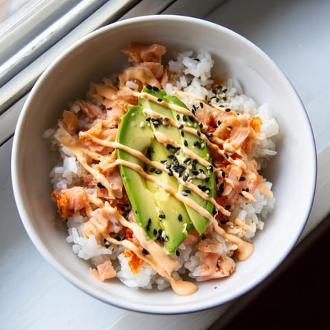 The Emily Mariko salmon rice bowl topped with green onions and sesame seeds, paired with crisp nori sheets for hand rolls.  