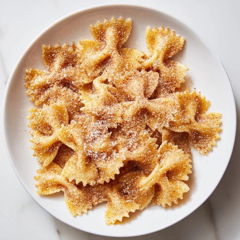 Bowtie pasta transformed into delicious Air Fryer Pasta Christmas Crack, coated with cinnamon sugar.