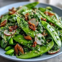 Vibrant snap pea and radish spring salad with creamy tahini dressing, ready for serving.